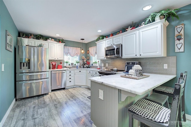 12118 261st Ave E, Buckley, WA 98321 - kitchen featuring stainless steel appliances, a peninsula, light wood-type flooring, white cabinetry, and recessed lighting