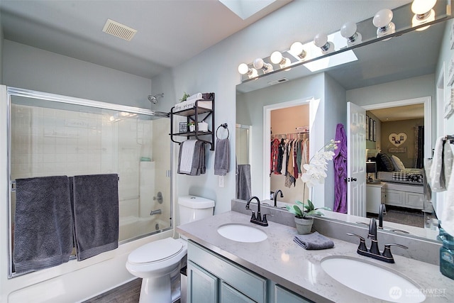 12118 261st Ave E, Buckley, WA 98321 - full bathroom featuring combined bath / shower with glass door, ensuite bathroom, double vanity, a skylight, and wood finished floors