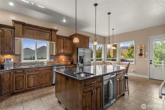 1075 Ridge Crest Dr, Wenatchee, WA 98801 - kitchen featuring beverage cooler, stainless steel appliances, a kitchen island with sink, decorative backsplash, and recessed lighting