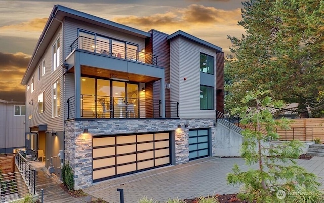 8707 116th Ave NE Unit A, Kirkland, WA 98033 - view of front of home featuring a balcony, stone siding, a garage, and driveway