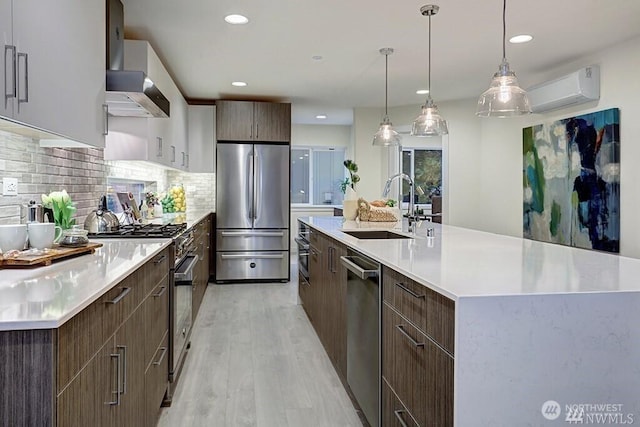 8707 116th Ave NE Unit A, Kirkland, WA 98033 - kitchen featuring stainless steel appliances, modern cabinets, a wall unit AC, light wood-type flooring, and wall chimney range hood