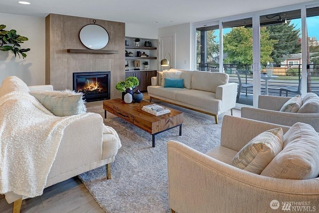 8707 116th Ave NE Unit A, Kirkland, WA 98033 - living area with a large fireplace, built in shelves, wood finished floors, and recessed lighting
