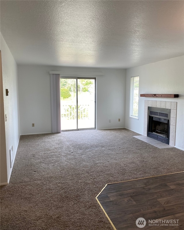 6003 Broadway, Everett, WA 98203 - unfurnished living room featuring carpet, a fireplace, and a textured ceiling