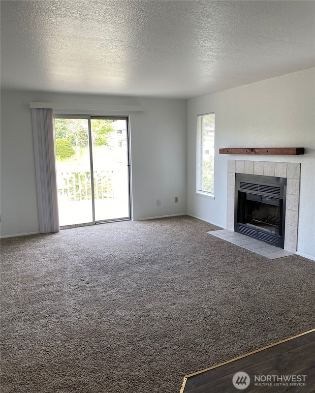6003 Broadway, Everett, WA 98203 - unfurnished living room featuring carpet, a tiled fireplace, and a textured ceiling