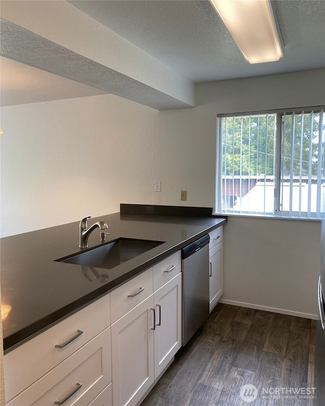 6003 Broadway, Everett, WA 98203 - kitchen featuring stainless steel dishwasher, dark countertops, dark wood finished floors, and white cabinets