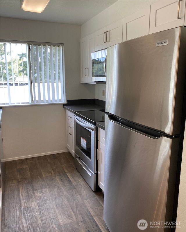 6003 Broadway, Everett, WA 98203 - kitchen featuring appliances with stainless steel finishes, dark countertops, white cabinetry, and dark wood finished floors