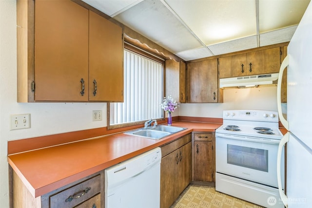238 NE Damson Pl, College Place, WA 99324 - kitchen featuring white appliances, under cabinet range hood, brown cabinetry, light floors, and light countertops