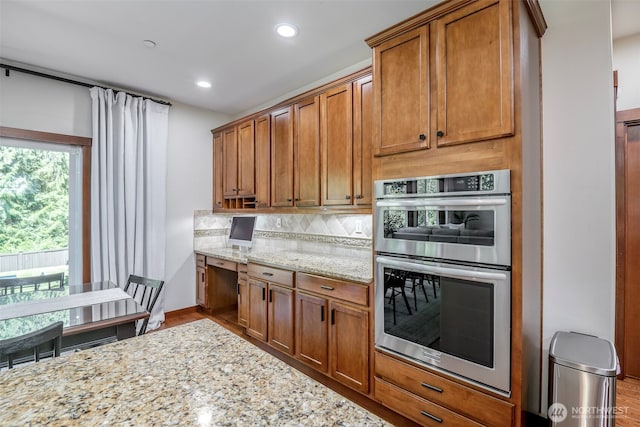 1141 Bell Hill Pl, Dupont, WA 98327 - kitchen with double oven, brown cabinets, light stone counters, tasteful backsplash, and recessed lighting