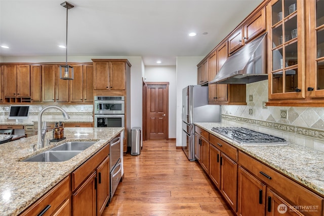 1141 Bell Hill Pl, Dupont, WA 98327 - kitchen featuring appliances with stainless steel finishes, under cabinet range hood, brown cabinets, light stone counters, and recessed lighting