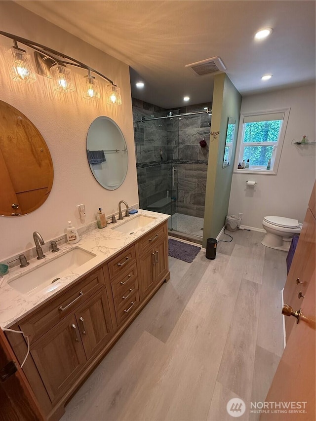 5645 Lento Pl SE, Olympia, WA 98513 - bathroom featuring double vanity, a shower stall, wood finished floors, and recessed lighting