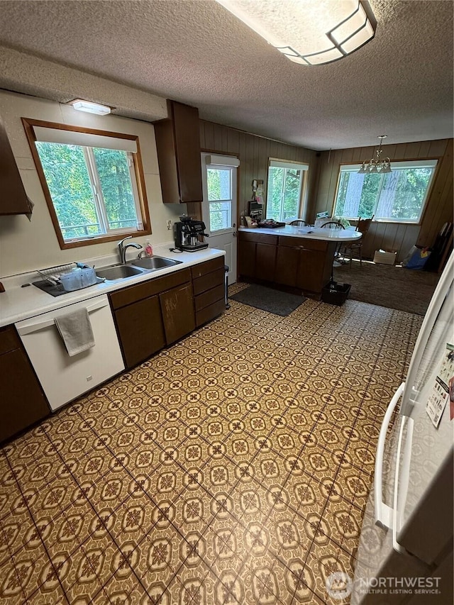 5645 Lento Pl SE, Olympia, WA 98513 - kitchen with a textured ceiling, light countertops, plenty of natural light, dark brown cabinets, and wood walls