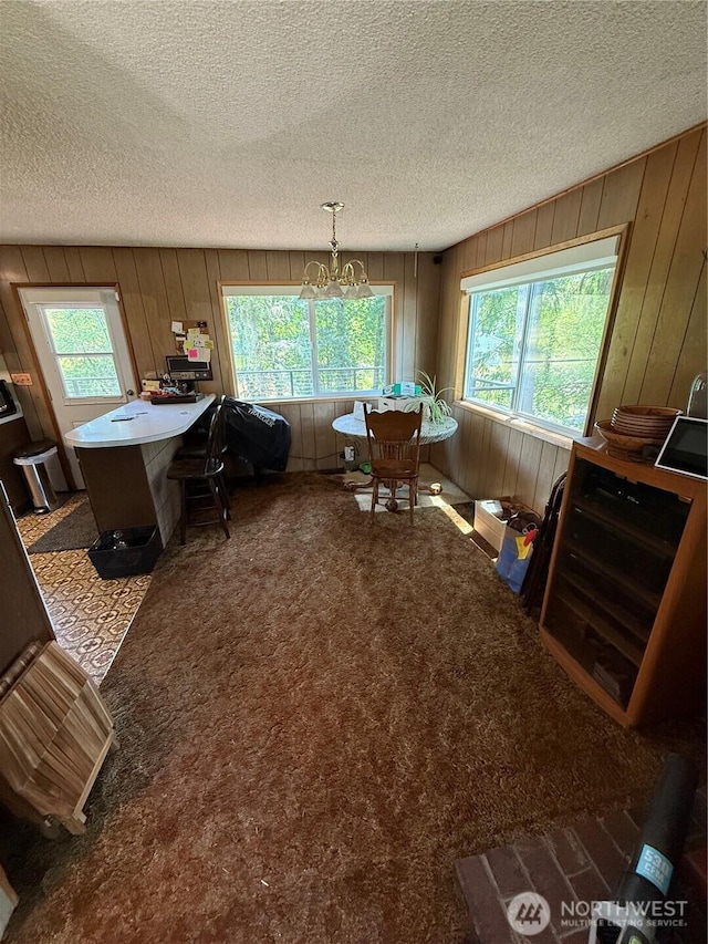 5645 Lento Pl SE, Olympia, WA 98513 - dining area featuring plenty of natural light, a textured ceiling, wood walls, a chandelier, and carpet