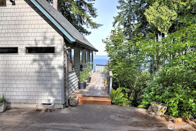 662 E Stadium Beach Rd E, Grapeview, WA 98546 - view of side of home featuring a deck with water view and roof with shingles
