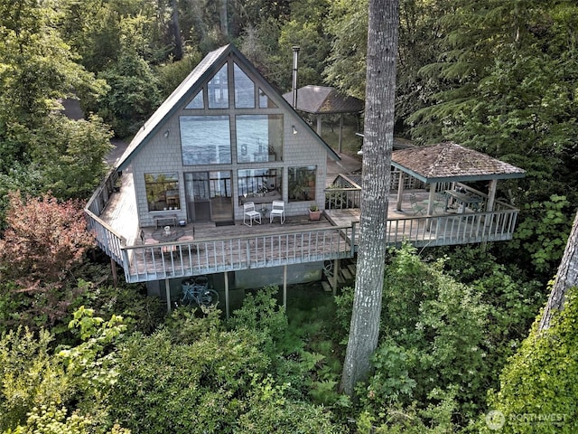 662 E Stadium Beach Rd E, Grapeview, WA 98546 - back of property with a deck and a view of trees