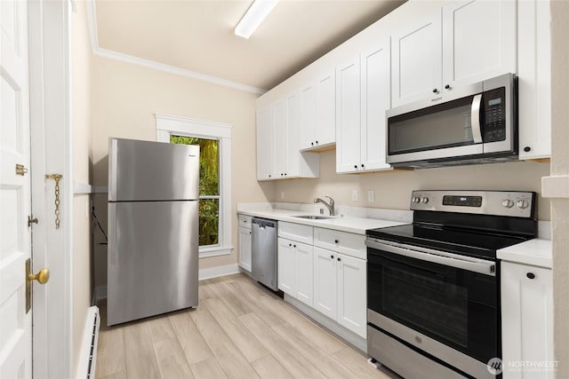 3722 Oakes Ave, Everett, WA 98201 - kitchen with appliances with stainless steel finishes, light countertops, white cabinetry, ornamental molding, and light wood-type flooring