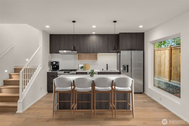 926 23rd Ave, Seattle, WA 98122 - kitchen with appliances with stainless steel finishes, under cabinet range hood, a center island, modern cabinets, and dark brown cabinets