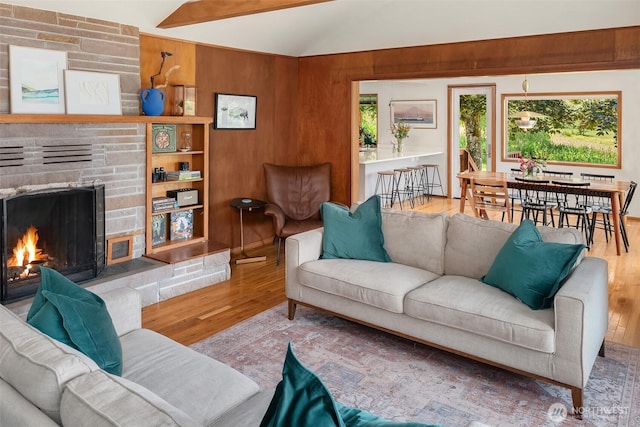 16305 Crescent Dr SW, Vashon, WA 98070 - living room featuring wood finished floors, vaulted ceiling, a stone fireplace, and wood walls