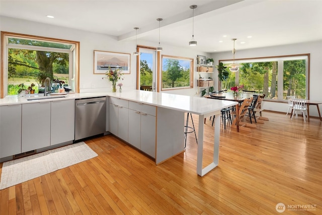 16305 Crescent Dr SW, Vashon, WA 98070 - kitchen with dishwasher, light countertops, light wood finished floors, decorative light fixtures, and modern cabinets