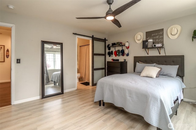 6530 Newaukum Pl NE, Bremerton, WA 98311 - bedroom with a barn door, wood finished floors, connected bathroom, and ceiling fan