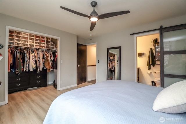 6530 Newaukum Pl NE, Bremerton, WA 98311 - bedroom featuring a spacious closet, wood finished floors, a closet, a barn door, and connected bathroom