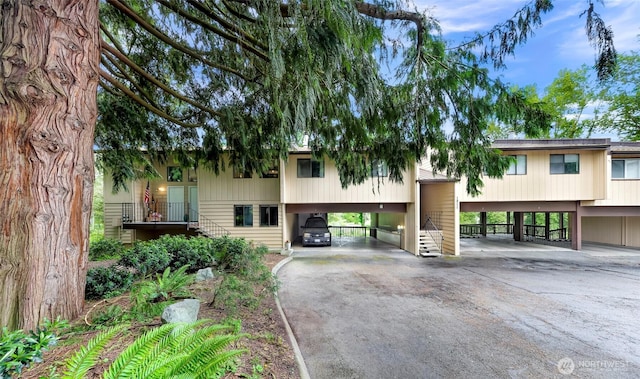 1211 N 8th St Unit 2, Mount Vernon, WA 98273 - view of building exterior featuring a carport, asphalt driveway, and stairway