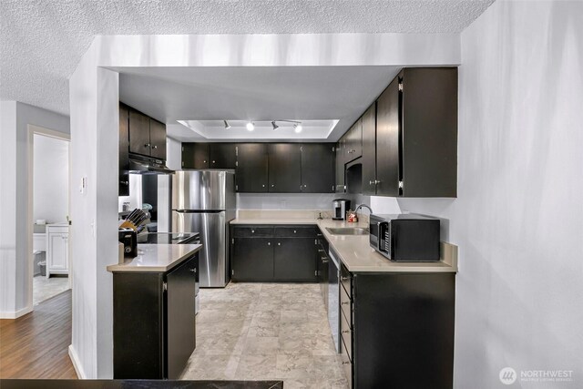 1211 N 8th St Unit 2, Mount Vernon, WA 98273 - kitchen with black microwave, freestanding refrigerator, a textured ceiling, light countertops, and under cabinet range hood
