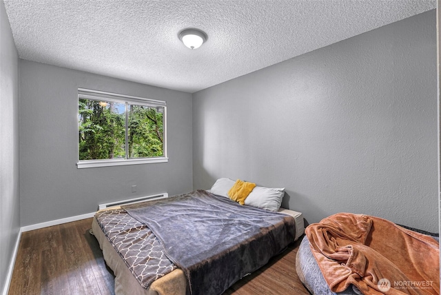 1211 N 8th St Unit 2, Mount Vernon, WA 98273 - bedroom with a baseboard heating unit, wood finished floors, and a textured ceiling