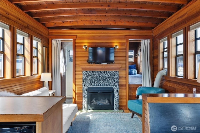 2401 N Northlake Way Unit E7, Seattle, WA 98103 - living room featuring a wood ceiling with exposed beams, healthy amount of natural light, wooden walls, and a fireplace