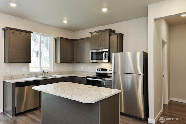 2309 158th Street Ct E, Tacoma, WA 98445 - kitchen with stainless steel appliances, dark brown cabinetry, dark wood-type flooring, light stone countertops, and a kitchen island