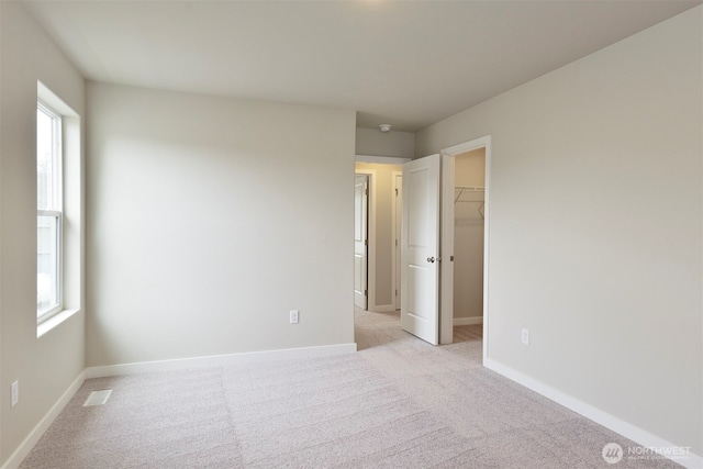 2309 158th Street Ct E, Tacoma, WA 98445 - unfurnished bedroom featuring a walk in closet, multiple windows, light colored carpet, and a closet