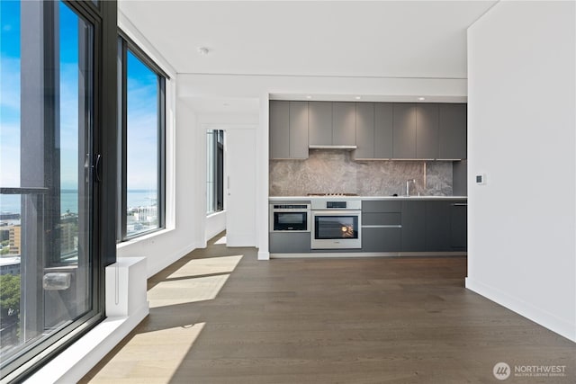 2510 6th Ave Unit 2306, Seattle, WA 98121 - kitchen featuring stainless steel oven, modern cabinets, gray cabinetry, and backsplash