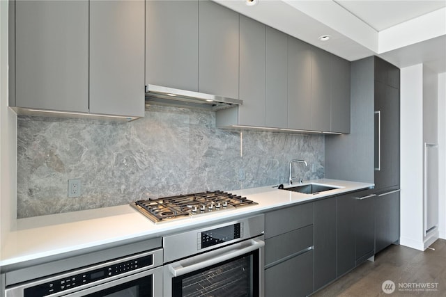 2510 6th Ave Unit 2306, Seattle, WA 98121 - kitchen with appliances with stainless steel finishes, under cabinet range hood, gray cabinetry, modern cabinets, and light countertops
