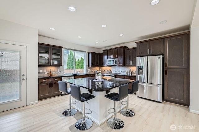 3720 195th Pl SE, Bothell, WA 98012 - kitchen with appliances with stainless steel finishes, a breakfast bar, dark brown cabinetry, recessed lighting, and light wood finished floors