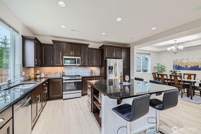 3720 195th Pl SE, Bothell, WA 98012 - kitchen with stainless steel appliances, healthy amount of natural light, light wood-style flooring, a kitchen bar, and recessed lighting