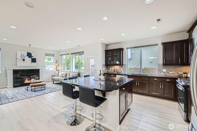 3720 195th Pl SE, Bothell, WA 98012 - kitchen featuring appliances with stainless steel finishes, a breakfast bar area, dark brown cabinets, light wood-type flooring, and recessed lighting