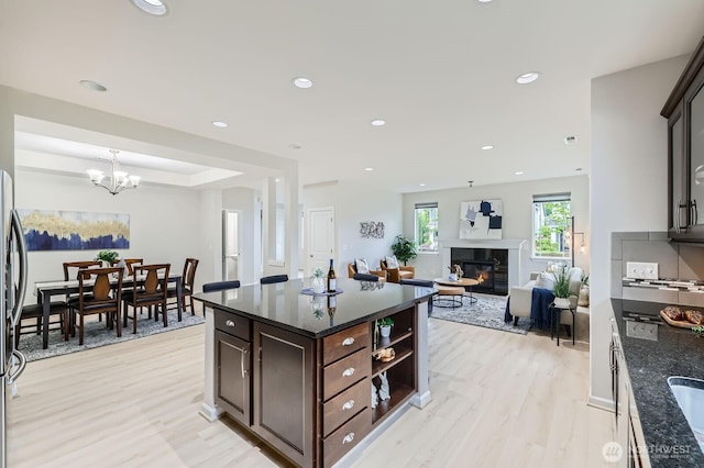 3720 195th Pl SE, Bothell, WA 98012 - kitchen with light wood finished floors, dark brown cabinetry, a high end fireplace, dark stone counters, and recessed lighting