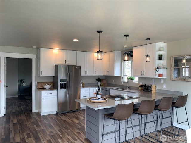 217 San Remo Ln, Chelan, WA 98816 - kitchen featuring high end refrigerator, a peninsula, white cabinets, a kitchen bar, and dark wood-type flooring