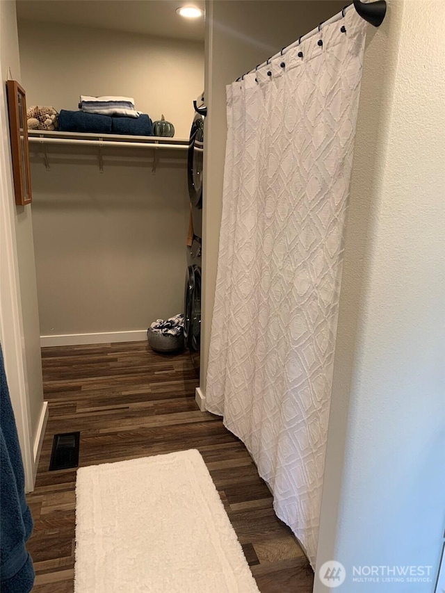 217 San Remo Ln, Chelan, WA 98816 - full bath featuring estacked washer and dryer, wood finished floors, a spacious closet, curtained shower, and recessed lighting