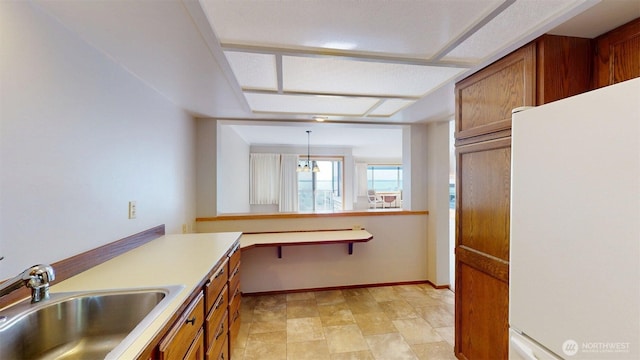 424 14th St # 202, Bellingham, WA 98225 - kitchen with freestanding refrigerator, brown cabinets, light countertops, and pendant lighting