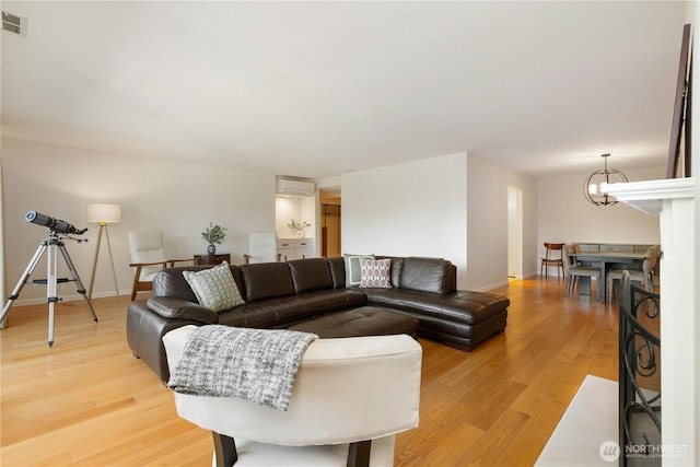 2565 Dexter Ave N Unit 103, Seattle, WA 98109 - living room with light wood-style floors, an AC wall unit, and a chandelier