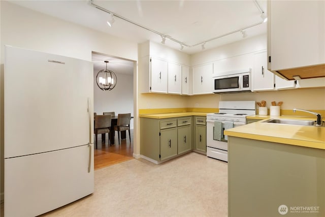 2565 Dexter Ave N Unit 103, Seattle, WA 98109 - kitchen with white appliances, rail lighting, light countertops, a chandelier, and white cabinetry