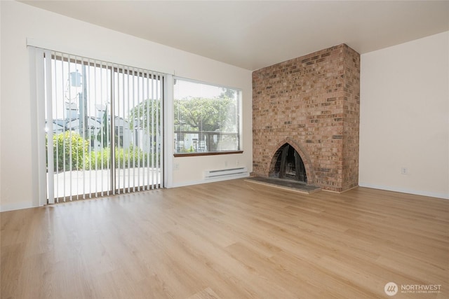 3421 23rd Ave W, Seattle, WA 98199 - unfurnished living room with wood finished floors, baseboard heating, and a brick fireplace