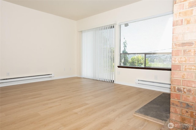 3421 23rd Ave W, Seattle, WA 98199 - unfurnished room featuring a baseboard heating unit and wood finished floors