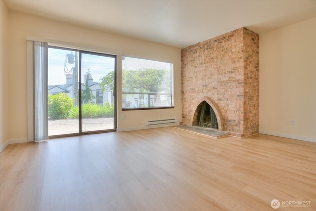 3421 23rd Ave W, Seattle, WA 98199 - unfurnished living room featuring baseboard heating, wood finished floors, and a brick fireplace