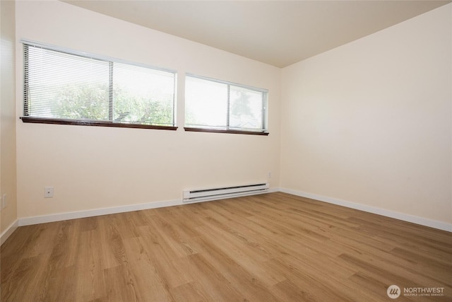 3421 23rd Ave W, Seattle, WA 98199 - unfurnished room featuring a baseboard heating unit and light wood-style flooring