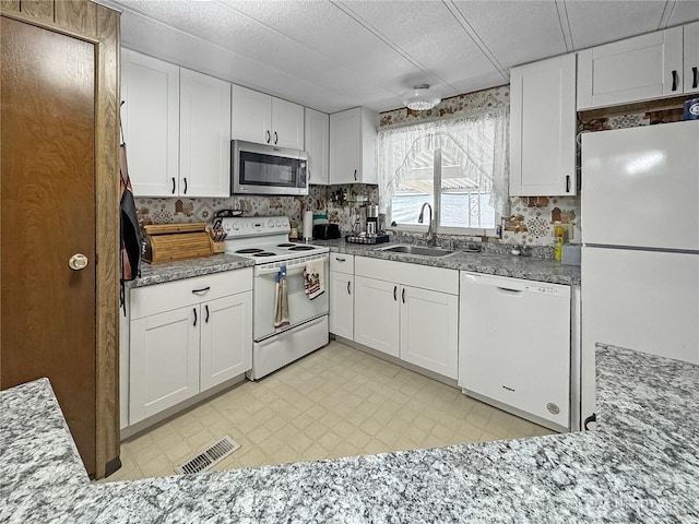 1385 Samuel Dr, Walla Walla, WA 99362 - kitchen with white appliances, white cabinets, light flooring, and light stone countertops