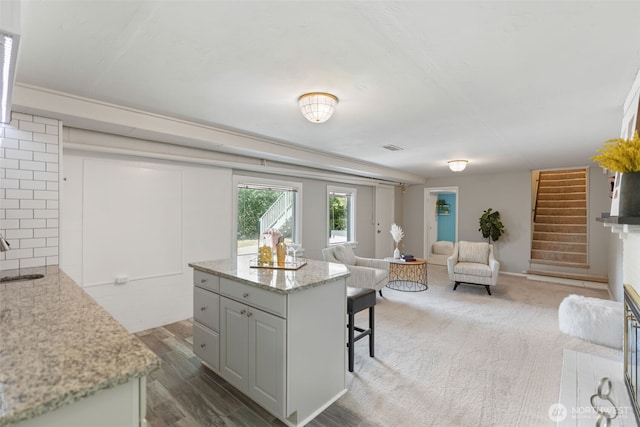 2322 Browns Point Blvd NE, Tacoma, WA 98422 - kitchen featuring open floor plan, a kitchen breakfast bar, light stone counters, a kitchen island, and wood finished floors