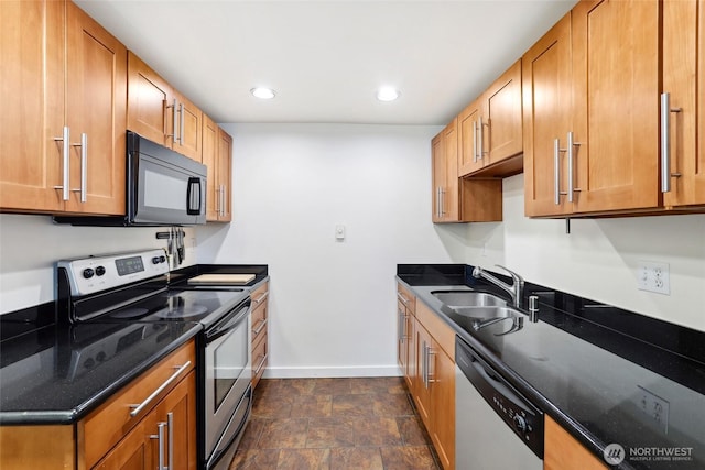 9013 16th Ave SW Unit 8, Seattle, WA 98106 - kitchen with stainless steel appliances, dark stone counters, recessed lighting, stone finish floors, and brown cabinets
