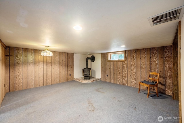 2991 Main St, Custer, WA 98240 - below grade area with wooden walls, carpet flooring, and a wood stove