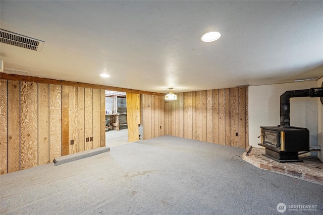 2991 Main St, Custer, WA 98240 - finished basement with carpet floors, wood walls, and a wood stove